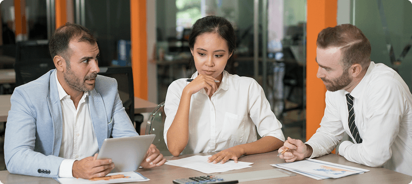 Three thoughtful marketing analysts working with diagrams